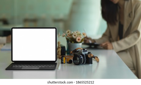 Close up view of portable workspace with tablet, camera and accessories on the table