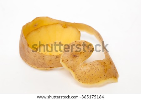 Close up view of the potato skin pealing process on a white background.