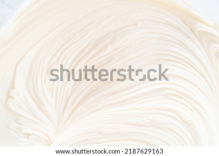 Close up view. Preparing vanilla buttercream frosting for decorating funfettti bundt cake.