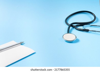 Close Up View Of Prescription Pad And Medical Stethoscope On Blue Background.