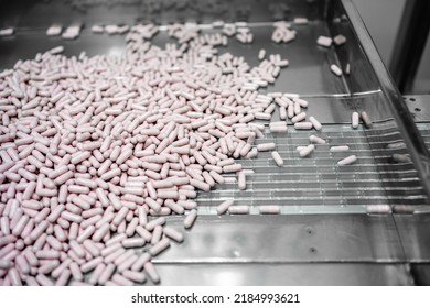 Close Up View Of Process Production Line Pink Capsules Supplement, Medical Industry Concept.