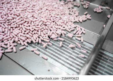 Close Up View Of Process Production Line Pink Capsules Supplement, Medical Industry Concept.