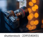 Close up view to professional digital camera with LCD screen on a blurred background with bokeh effect.