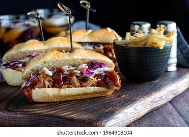 Close Up View Of A Pulled Pork Slider Served With Fries And Cola Beverages, Against A Dark Background.