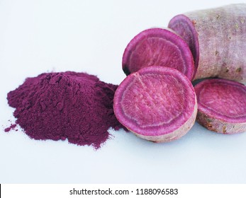 Close Up View Of Purple Sweet Potato Powder With Raw Purple Sweet Potato, Cut In Pieces, Isolated