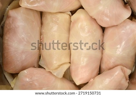 Close up view of raw sarma rolls (pickled cabbage leaf stuffed with meat and rice) packed tightly in a pot for cooking