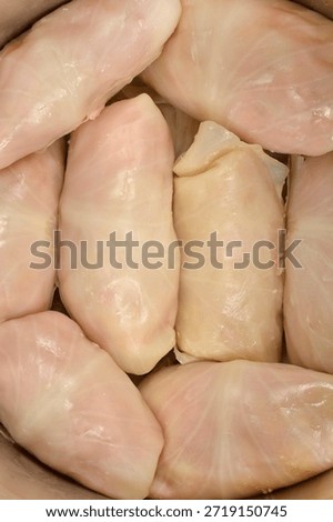 Close up view of raw sarma rolls (pickled cabbage leaf stuffed with meat and rice) packed tightly in a pot for cooking