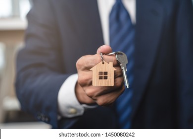 Close up view realtor broker holding home keychain in his hand. - Shutterstock ID 1450080242