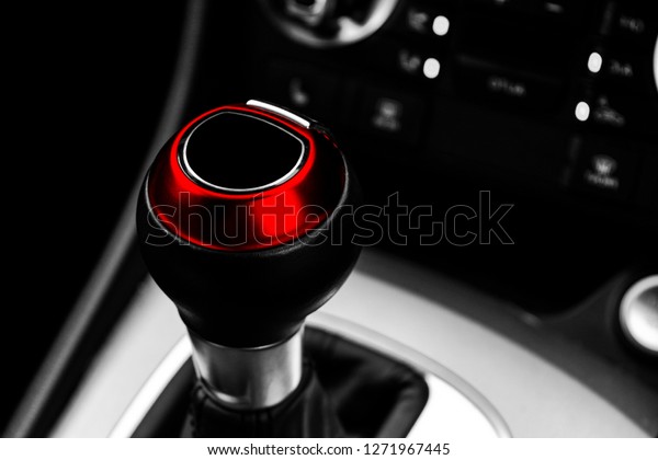 Close up view of a red gear lever shift. Manual\
gearbox. Car interior details. Car transmission. Soft lighting.\
Abstract view. Car\
detailing
