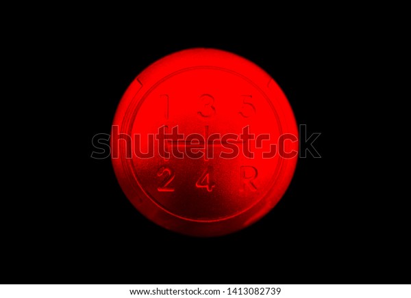 Close up view of a\
red gear lever shift isolated on black background. Manual gearbox.\
Car interior details. Car transmission. Soft lighting. Abstract\
view. Car detailing
