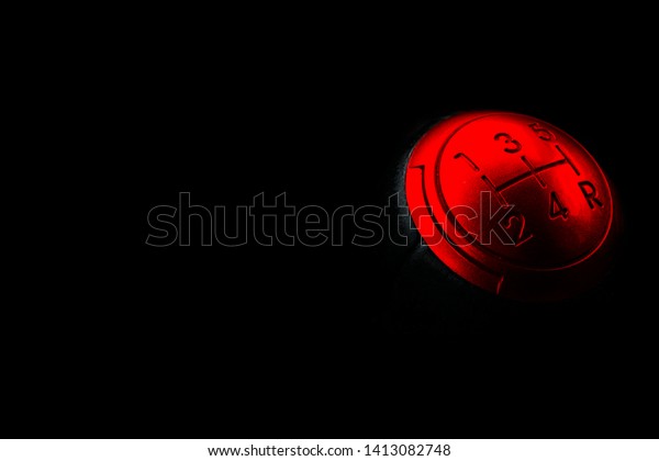 Close up view of a\
red gear lever shift isolated on black background. Manual gearbox.\
Car interior details. Car transmission. Soft lighting. Abstract\
view. Car detailing