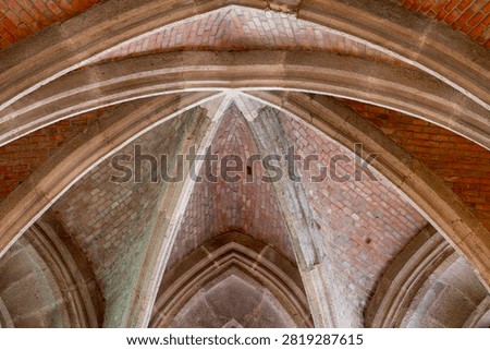 A close view of the ribbed brick and stone vaulting shows the intricate structural pattern of a medieval Gothic chapel ceiling within the excavated royal palace complex at Buda Castle in Budapest, Hungary, with fine carved detailing visible along the surrounding surfaces and edges.