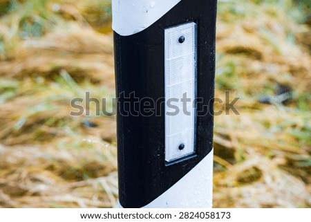 A close up view of a roadside delineator post
