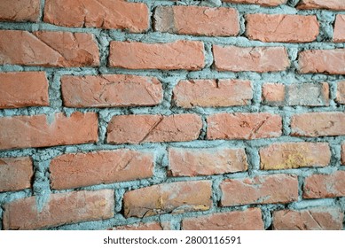 Close up view of a rough red brick wall texture