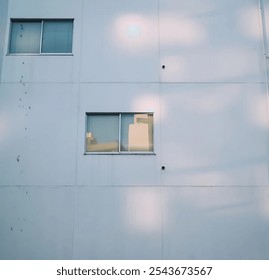 a close up view of a section of a white building featuring two rectangular window