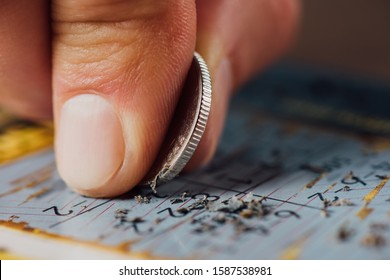 Close Up View Of Silver Coin In Hand Of Gambler Scratching Lottery Card