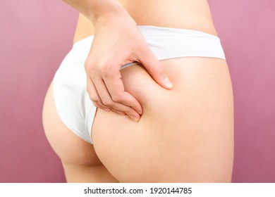 Close up view of a slender woman in lingerie on a pink background. Cellulite problem concept