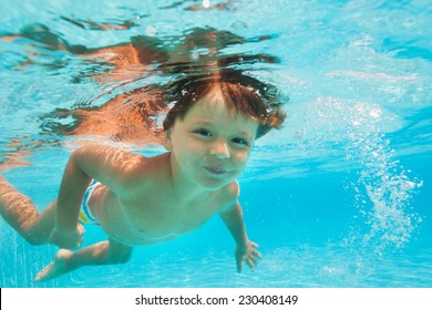 Close Up View Of Small Boy Swimming Under Water