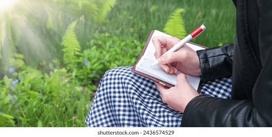 Close up view smart author sit notice sheet work memo mail empty page read forest green grass yard space Closeup old vintage youth teen age lesson pupil arm hold draw pencil art sketch teach open card