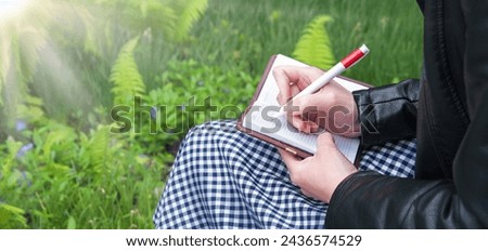 Close up view smart author sit notice sheet work memo mail empty page read forest green grass yard space Closeup old vintage youth teen age lesson pupil arm hold draw pencil art sketch teach open card