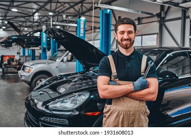 Close Up View Of A Smiling Mechanic Inside His Auto Repair Shop. Front View.