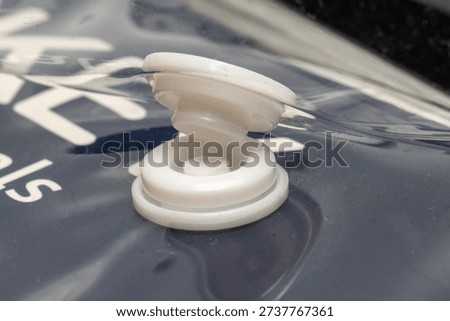 close up view of a snap button clip on plastic packaging.