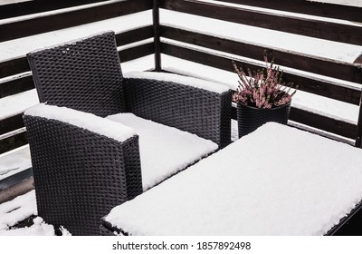 Close Up View Of Snowy Synthetic Plastic Rattan And Glass Garden Furniture On Cold Winter Day. Garden Furniture Maintenance Concept.