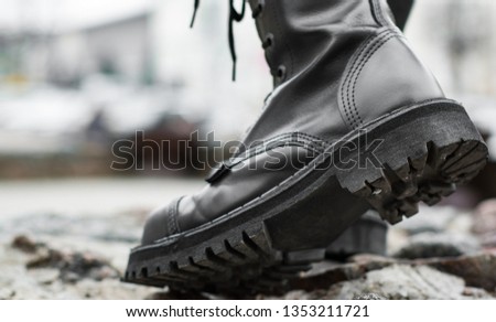 Close up view sole black leather boot on stone nature background outdoor