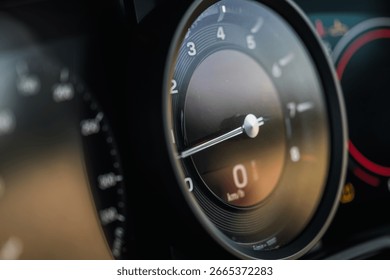 Close view of a speedometer and dashboard, showcasing precise details of the luxury car's instrumentation as sunlight reflects on the surface.