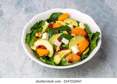 Close Up View Of Spinach, Avocado Salad With Orange, Pomegranate And Walnut