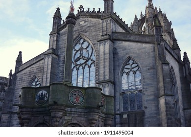 Close up view of St. Giles Cathedral front exterior in morning at The Royal Mile in Edinburgh, UK with cloudy blue sky background. No people.