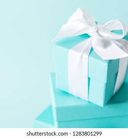 Close View The Stack Of Boxes Tied With Silk Ribbon, Lying On Each Other On Tiffany Blue Color Pastel Background. Best Gift For Girls Concepts.