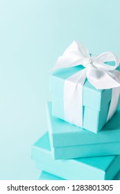 Close View The Stack Of Boxes Tied With Silk Ribbon, Lying On Each Other On Tiffany Blue Color Pastel Background. Best Gift For Girls Concepts.