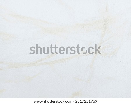 Close up view of subtle yellow water stain mark on white painted concrete wall surface texture.
