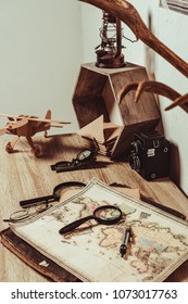 close up view of table with map, magnifying glasses and retro photo camera