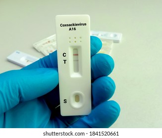 Close view of technician or technologist hand hold a device of Coxsackievirus A16 rapid screening test, showing positive result.