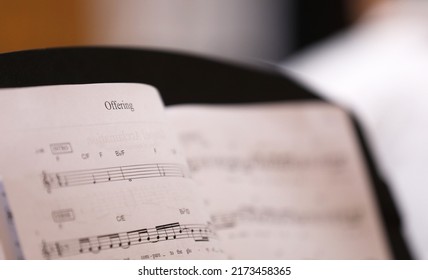 A close up view of the text or word 'Offering'. The christian hymn Offering musical score or sheet music with notes for the choir or musicians.  - Shutterstock ID 2173458365