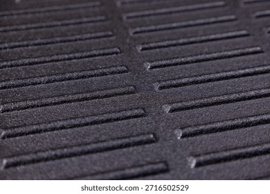 Close view of a textured surface with parallel lines and grooves during daylight