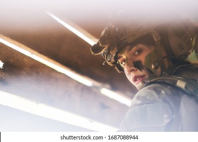 Close Up View Through Hole Of Wood Wall Of Beautiful Soldier Woman With Combat Suit Look To The Camera.