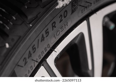 Close up view of tire with tire width, height and wheel diameter designation. Tire size types labels.