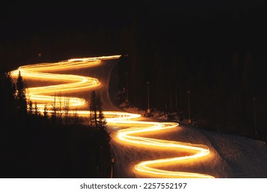 Close up view of the torchlight procession, with light-paint effect, along the ski slope of Mount Lussari the first day of January, at night, during winter season