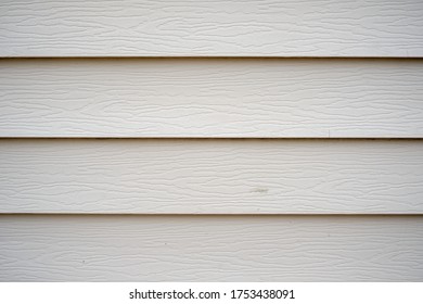 Close Up View Towards Light Tone Vinyl Siding Of A New Home.