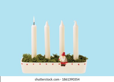 Close up view of traditional advent candlestick with one lighted candle  symbolizing first advent isolated on blue background.