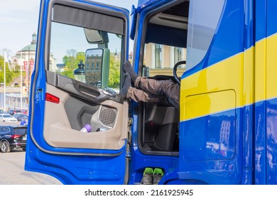 Close Up View Of Truck Driver Taking Rest Pause From Work By Putting Legs On Open Door. Sweden.