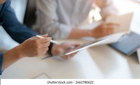 Close up view of two businessman consulting on their project with digital tablet and document file on white table - Shutterstock ID 1662780622