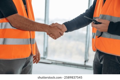 Close up view of two construction site workers making handshake, meet. - Powered by Shutterstock - Get 15% off with code: PIKWIZARD15