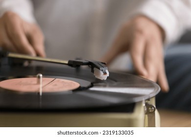 Close up view unknown female using old-fashioned equipment to listening favourite music on vinyl record old turntable player. Classical melody for retro style sound lovers, leisure, nostalgic mood - Shutterstock ID 2319133035