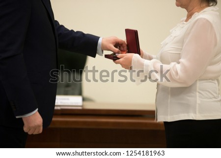 Close up view of unrecognizable businessman shaking hands  colleague presenting her gift for Boxing Day