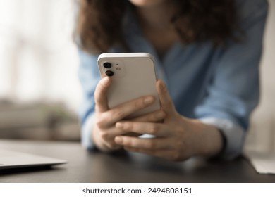 Close up view of unrecognizable woman using smartphone for browsing social media platforms, chatting with friends through messaging apps, watching videos on streaming services, playing mobile games