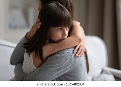 Close Up View Of Upset Little Daughter Cuddling Mother, Child Receiving Protection And Support From Mommy, Adopted Kid Girl And New Parent, Sole Custody, Offspring And Motherhood Connection Concept